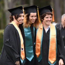 Three female students in graduation caps and gowns